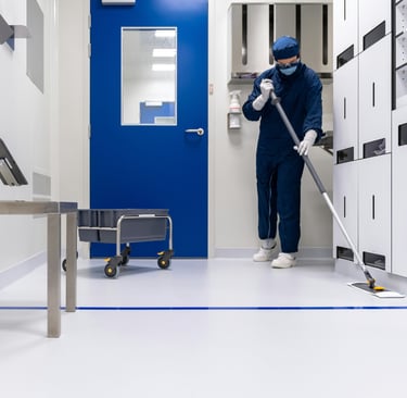 a person in a blue uniform cleaning a room