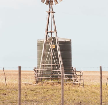 a tank in a field with a windmill