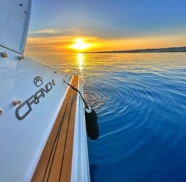 Side view of yacht cruising at sunset on Sicilian coast
