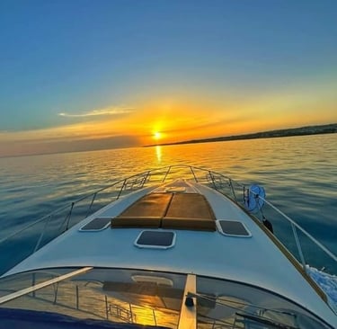 Front deck of luxury yacht facing calm sea at sunset in Siracusa, Sicily