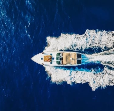 Aerial view of luxury motorboat cruising in blue Sicilian waters
