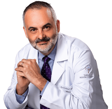 Foto do Dr. Eudes Tarallo sentado com as mãos unidas