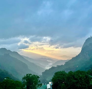 a mountain view of a valley with a sunset