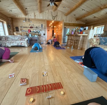 a group of people doing yoga exercises on a wooden floor