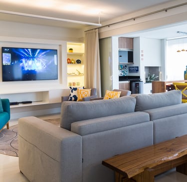 sala com televisão e sofá integrada com varanda e churrasqueira
