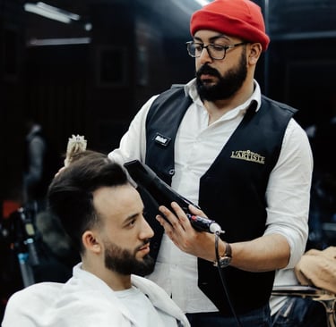 a man in a red hat is getting his hair styled
