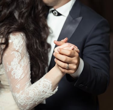 man and woman dancing wearing casual dresses as a DJ plays in the background