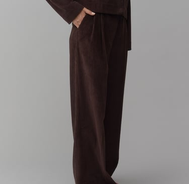 a man in a brown suit and red shoes