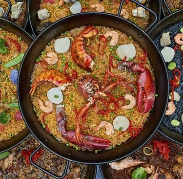 A colorful table filled with traditional Spanish dishes including paella, tortilla Española, and tap