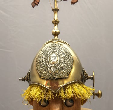 Model of a child's head wearing a shiny guard's helmet topped by a galloping horse