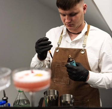 Barmeno rankos ruošia autorinį kokteilį su džinu ir šviežiomis uogomis