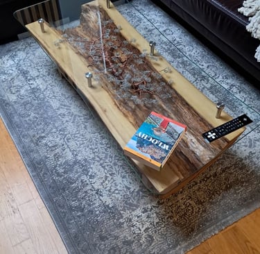 a coffee table with a glass top and a wooden table with a tv remote control