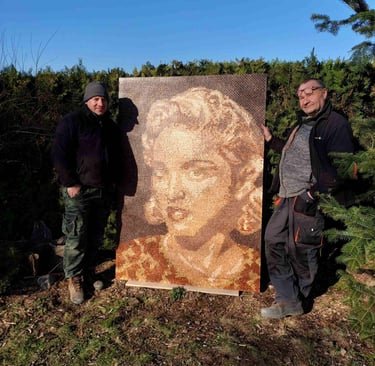 two men standing next to a painting of a woman's face