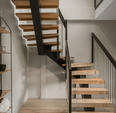 Escaleras modernas de madera y metal en una reforma integral en Valencia