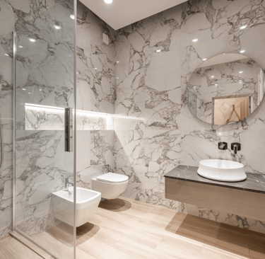 Baño moderno reformado en Valencia con acabados elegantes y grifería eficiente.