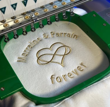 Broderie personnalisée élégante réalisée sur machine industrielle avec inscription “Marraine & Parra