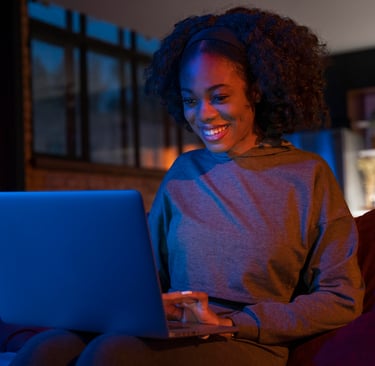 uma mulher sentada em um sofá com um laptop