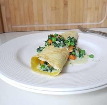 rolled German pancake on white plate with green veggies - copyright Tanja Dietzig