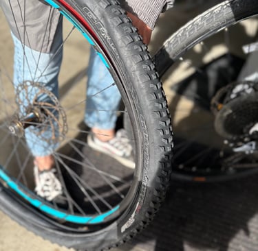 A person repairing a mountain bike tire and rim with knobby tread for off-road cycling.
