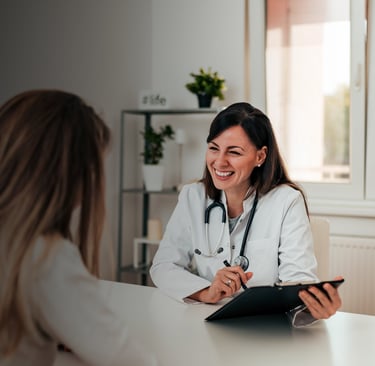 Ärztin im Gespräch mit Patientin in heller Praxis – Symbol für empathische Gesundheitskommunikation und Vertrauen.