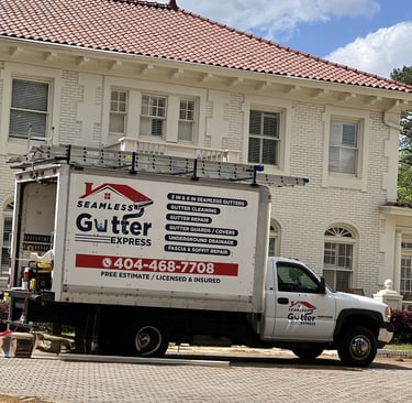 Work truck with Seamless Gutter Express branding parked at a job site.