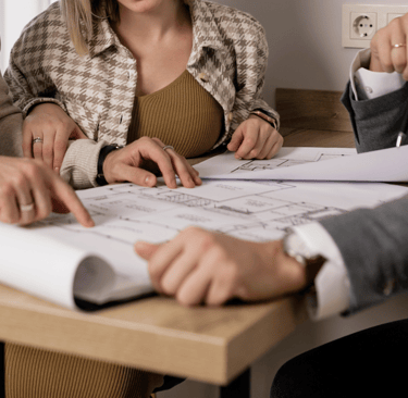 Clientes olhando o projeto da reforma do apartamento com o corretor.