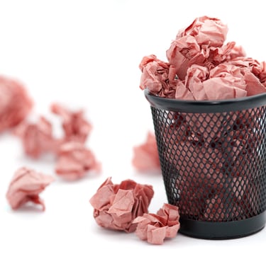 poubelle remplie de feuilles froissées