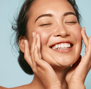 A lady smiling with glowing skin 
