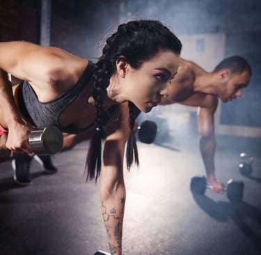 A lady and a man working out at gym 
