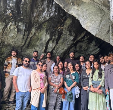 a group of people standing in front of a cave