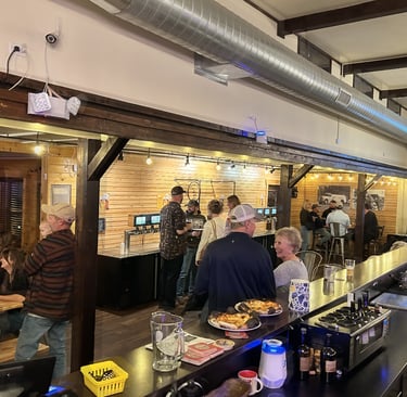 Guests roaming freely near the living room, community tables and self-service taps