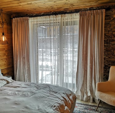 Rustikales Zimmer mit Bett und Industrielampen und Tagesvorhängen