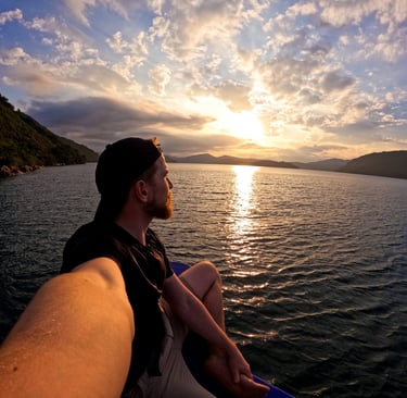 a man sitting on a boat in the ocean