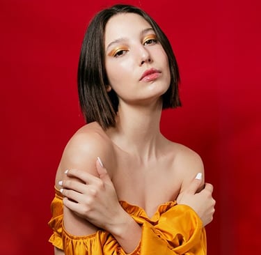 a woman with a bright orange top and a gold ring