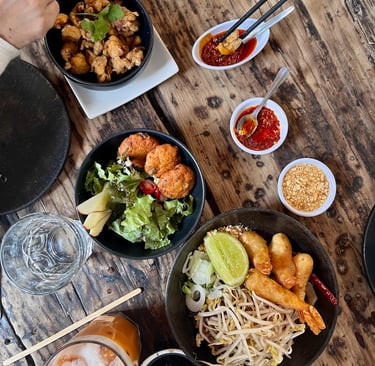 a table with bowls of food and chopsticks