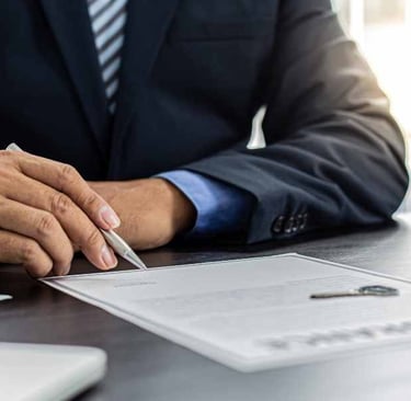 a man in a suit and tie is sitting at a desk with a pen and