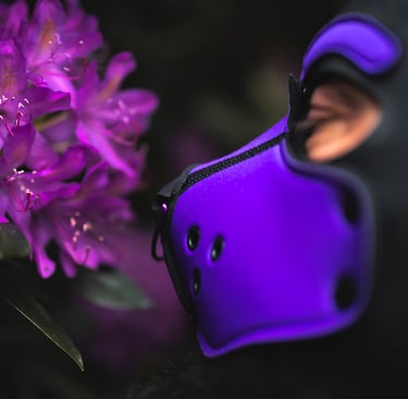Man in pup mask sniffing flowers.