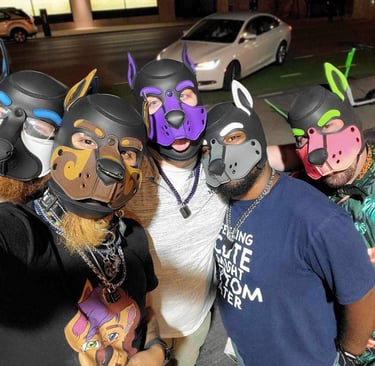 A group of men in pup masks posing on the street at night.