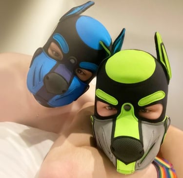 2 men posing for intimate picture wearing pup masks.