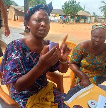 Mama Adzorhlor III, Queen Mother of Dagbamete, addressing the women while holding a menstrual cup.