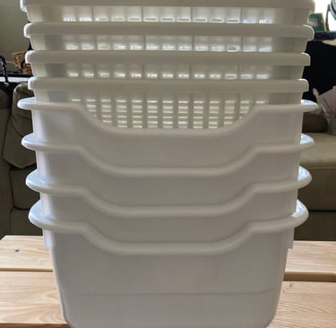 Plastic dishpans and baskets stacked up