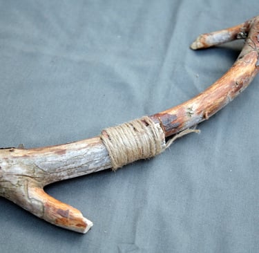percha construida con una rama de madera y cuerda