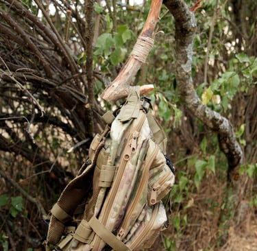 percha construida con una rama de madera y cuerda colgando de un arbol y una mochila de ellacolgando