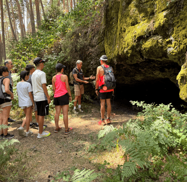 grupo de alumnos escuchando la explicacion del instructor sobre el refugio natural de una cuevando 