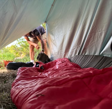 vista interior de un refugio de fortuna construido con un tarp y linea de cordino