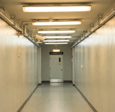 Pasillo de fábrica con cámara de videovigilancia apuntando al acceso de los vestuarios