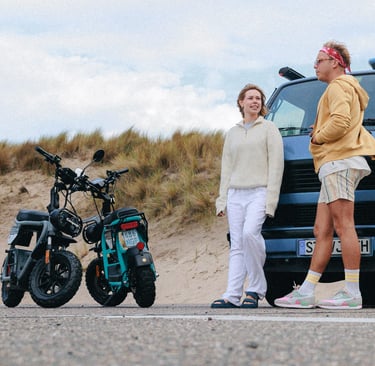 a man and woman standing next to a parked motorcycle