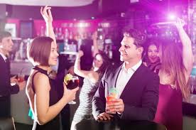 un homme et unen tenue de soiré discutent un verre à la main lors d'une soirée d'entreprise