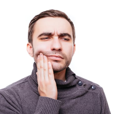 Man holding his cheek in pain due to a severe toothache or dental emergency.