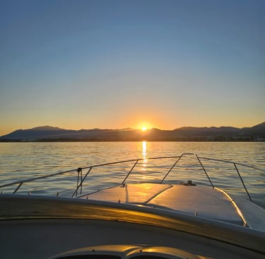 a boat in the water with the sun setting